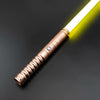 Gros plan d'un sabre laser métallique avec une lame jaune lumineuse sur fond sombre.