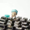 A close-up of a light blue character figure with a blind box keycap in the foreground.