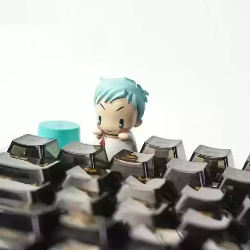 A close-up of a light blue character figure with a blind box keycap in the foreground.