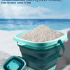 A teal folding storage bucket filled with white sand, shown next to a disassembled piece.