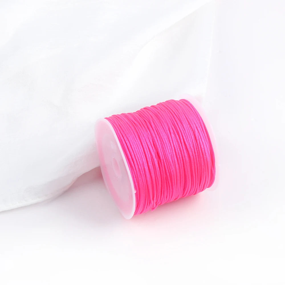 A pink spool of 0.8mm cotton nylon macrame cord for jewelry making and crafts.