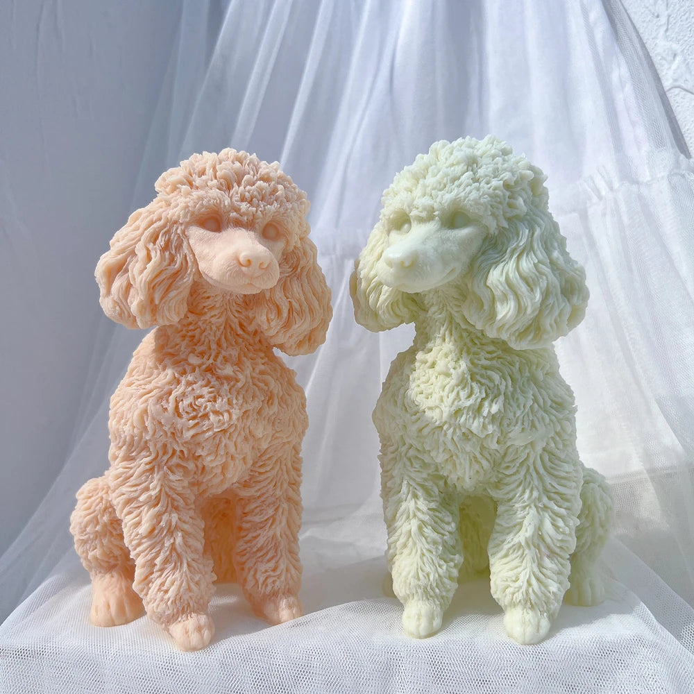 A pair of fluffy poodle dog silicone candle molds in peach and pale green colors displayed on a white fabric background.