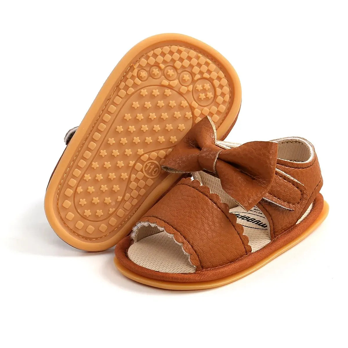 A pair of brown baby summer sandals with a soft anti-slip sole and bowknot.
