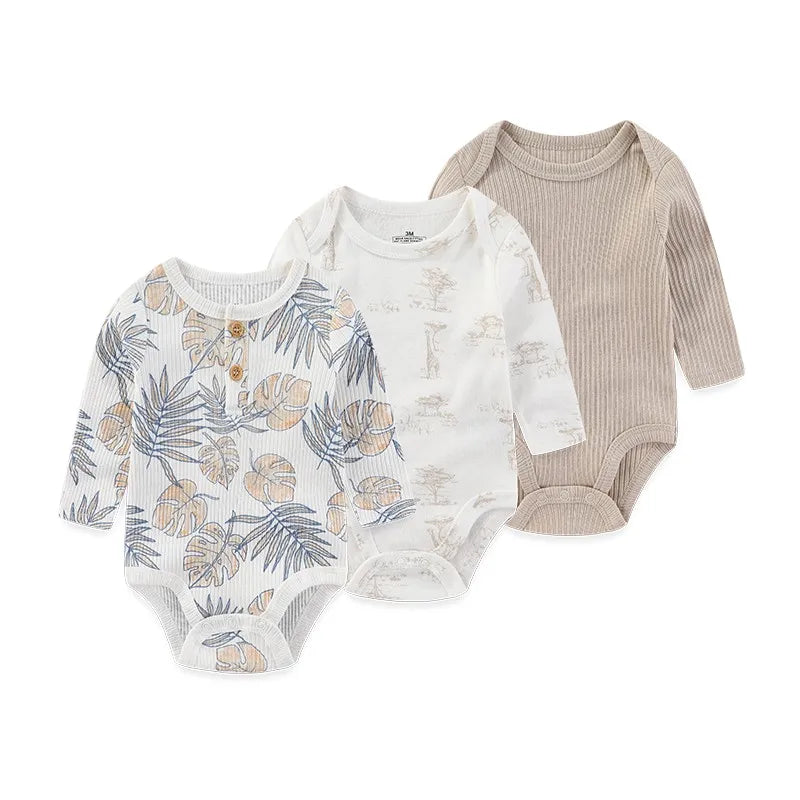 A set of three beige and white cotton baby bodysuits with long sleeves for infants.