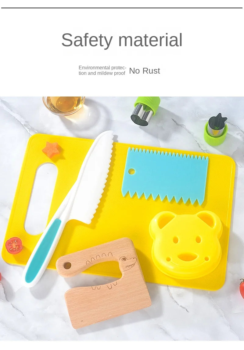 A yellow cutting board holds a white plastic knife, a blue plastic knife, and a yellow plastic bear shape.