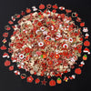 A dense collection of assorted red and gold metal pendants and charms for jewelry making
