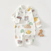 A white cotton long sleeve baby romper featuring scattered illustrations of yellow fruit, leaves, and rainbows.
