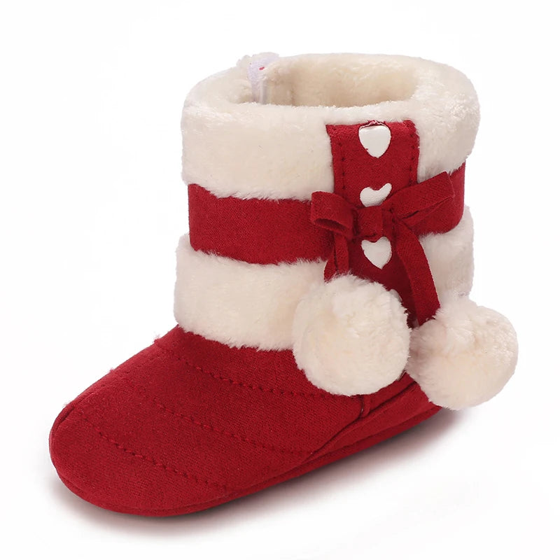 A pair of red and white faux fur baby winter boots with a bow detail.