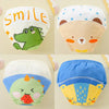 A set of four reusable cotton potty training pants featuring various animal designs including a smiling face, a bear, and a d