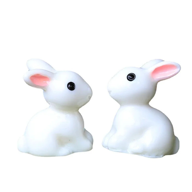 A pair of white miniature rabbit figurines used for fairy gardens or terrariums.