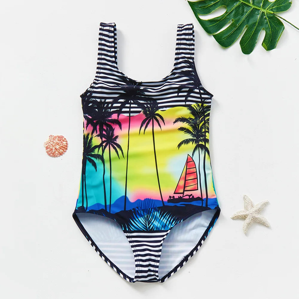 A black and white striped one-piece swimsuit featuring a tropical palm tree and rainbow design.