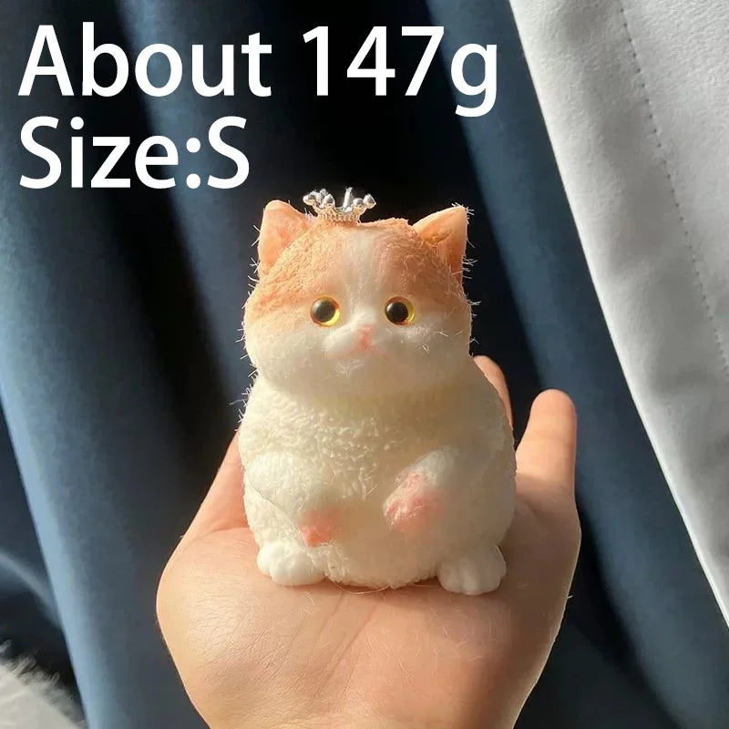 A small, fluffy orange and white cat-shaped squishy toy is held in a person's hand.