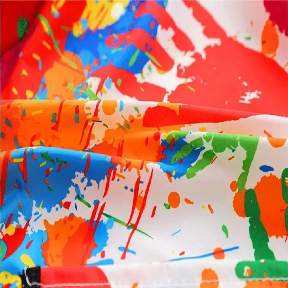 Close-up of a white fabric with colorful paint splatters in red, orange, blue, and green hues