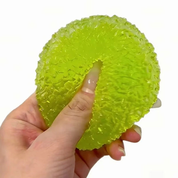 A hand is squeezing a bright lime green squishy stress relief fidget toy.