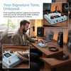 A portable multi-effects processor and amp modeler unit with a blue casing is shown on a wooden desk.