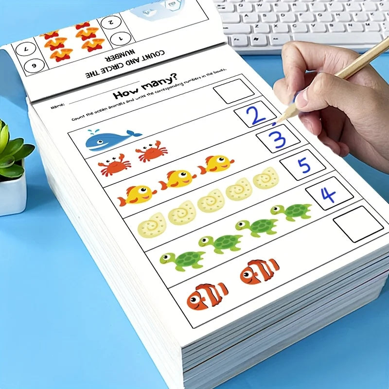 A hand is writing on a preschool math workbook that shows various animals for counting and number tracing exercises.
