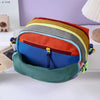 A colorful alpaca themed travel storage bag with three zippered compartments is displayed on a white surface.