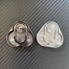 A pair of silver metal magnetic fidget sliders resting on a dark textured surface.