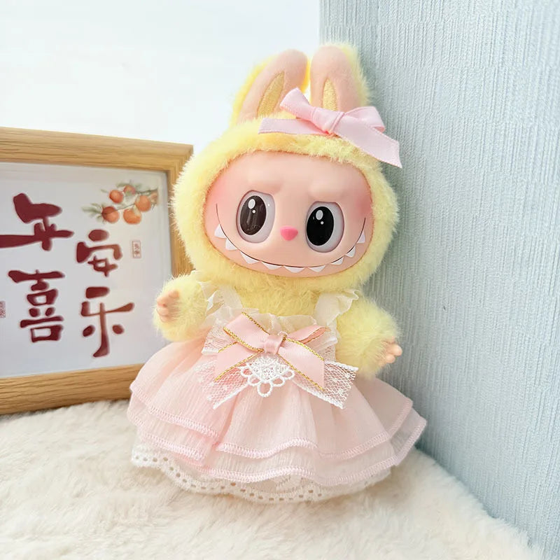 A fluffy yellow rabbit doll dressed in a pink strawberry party outfit with a bow and lace details.