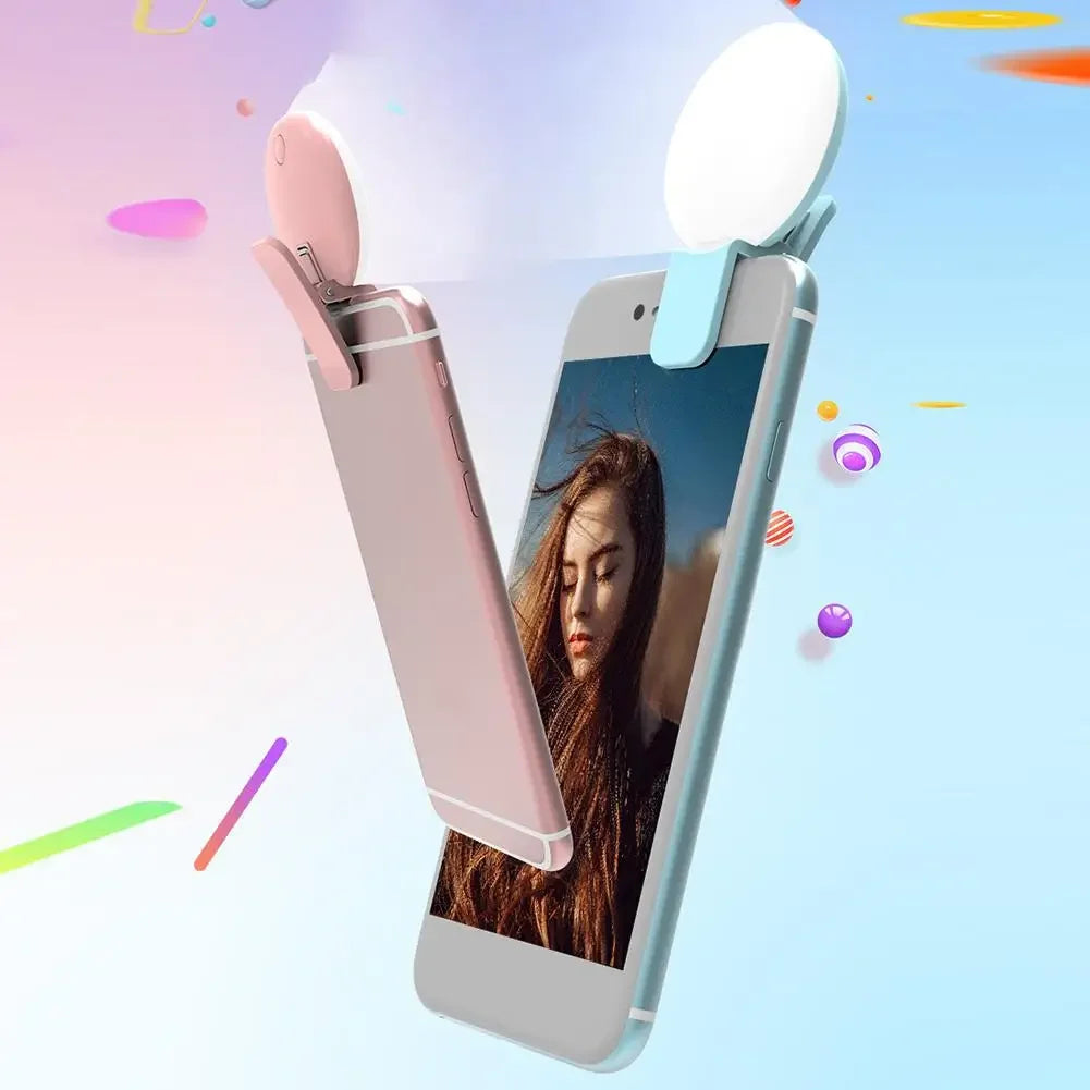 A portable LED selfie ring light is shown clipped onto a smartphone displaying a woman's portrait.