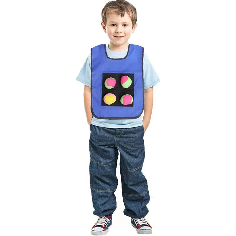 A young boy wearing a blue vest with colored circles for a sticky dodgeball game