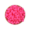 A pile of bright pink silicone round beads for jewelry making and DIY crafts arranged on a wooden surface.