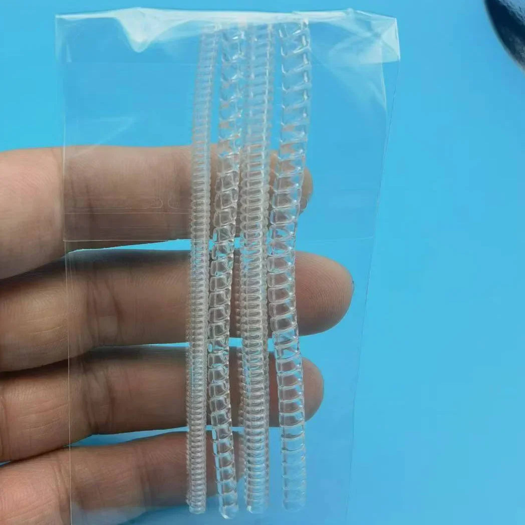 A clear plastic bag contains a set of transparent ring size adjusters or rings.
