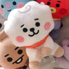 A white fluffy bear plush toy with pink accents and a small orange ribbon, surrounded by other cute plush toys.