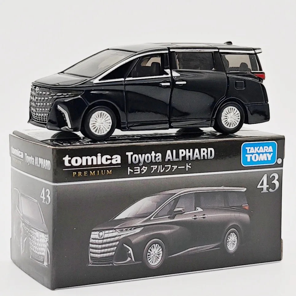 A black Tomica Toyota Alphard die-cast model car displayed in its packaging box.