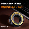 A black magnetic ring made of stainless steel and brass is shown on a dark surface next to a laptop.