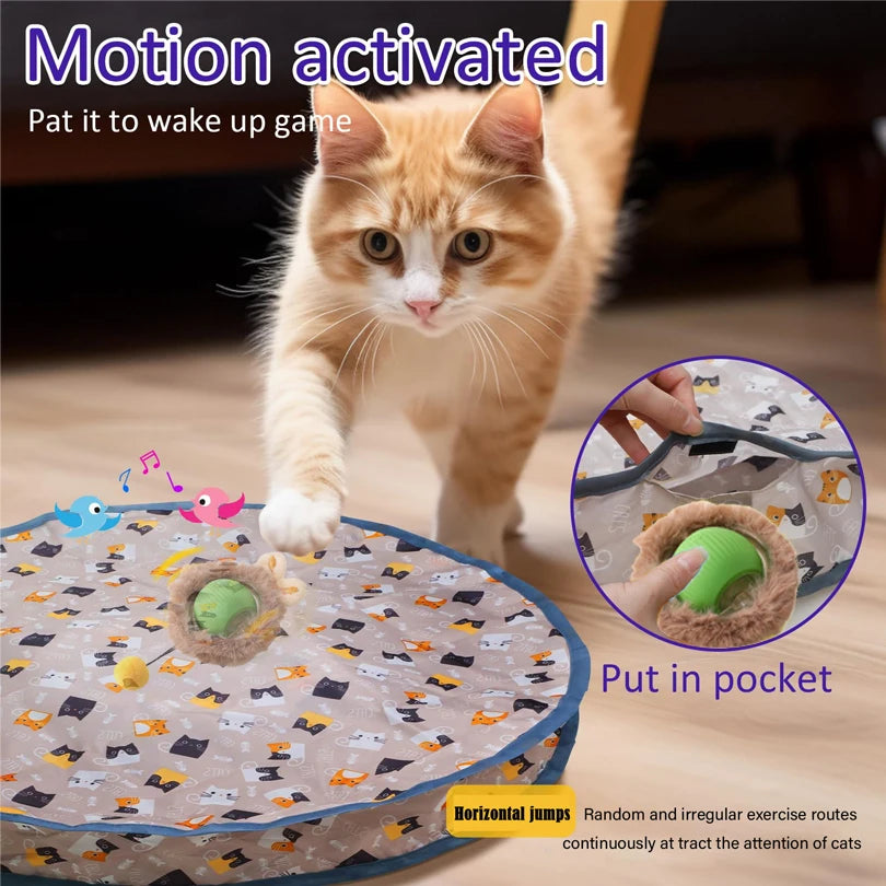 A fluffy orange cat is interacting with a motion-activated toy that features a rolling ball and hide elements.
