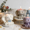 A small, light-colored elephant silicone mold is displayed with candles and various craft materials.