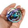 A hand holds a stack of colorful, iridescent spinner rings with various shades of blue, purple, and green.