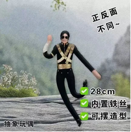 A black plush doll resembling Elvis Presley in a suit is shown against a blurred outdoor background.