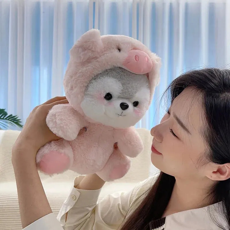 A woman is holding a pink husky plush toy with white fur against a light blue background.