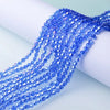 Blue faceted glass crystal beads strung together on a white surface.