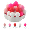 A pile of 50 silicone beads in various shades of pink and red, including candy pink, pink, scarlet red, white, and hot pink.