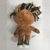 A brown collectible plush doll with black and tan hair, featuring a face and body.