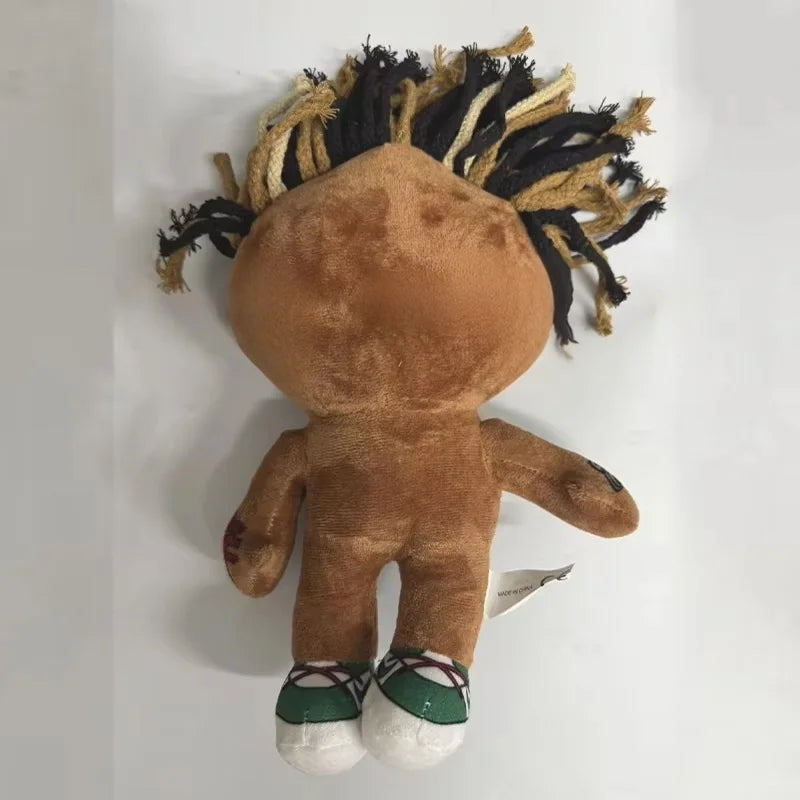 A brown collectible plush doll with black and tan hair, featuring a face and body.