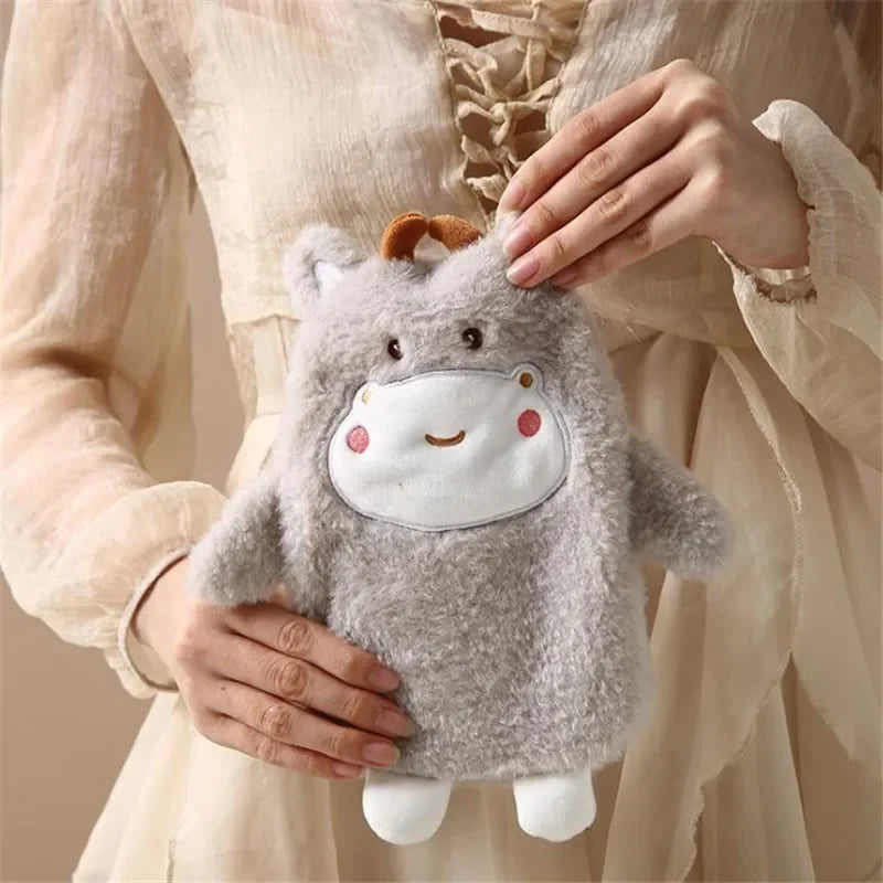 A gray plush toy shaped like a hippopotamus is being held by a person in a light-colored dress.