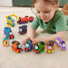 A young child is playing with various Thomas & Friends diecast train toys on a light carpet.