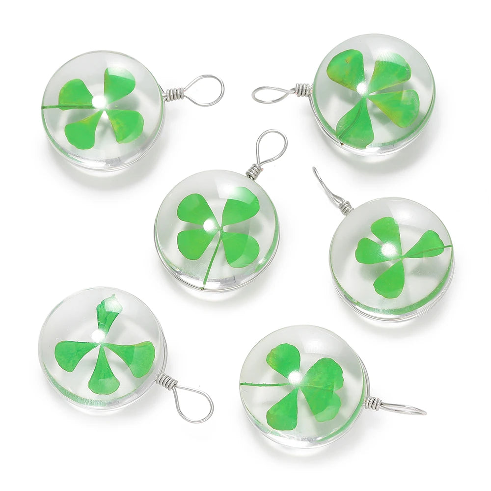 A set of handmade glass four leaf clover pendants with silver jump rings.