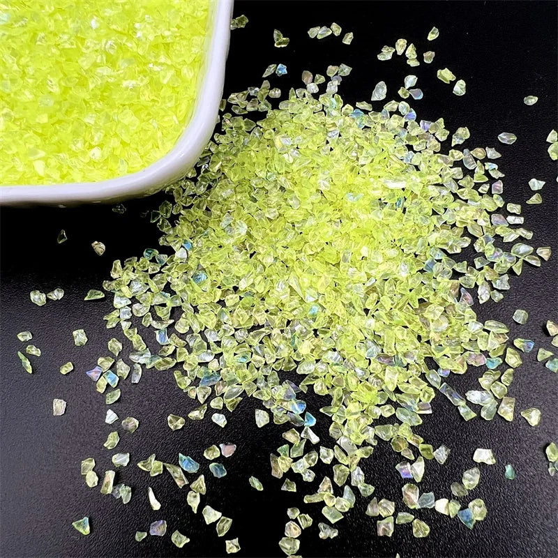 Bright yellow crushed glass crystals scattered on a dark surface.