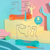 An electric touch maze game featuring orange and teal components, displayed on a light yellow surface.