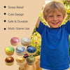 A smiling young boy holds a colorful squishy dumpling stress relief toy in his hand.