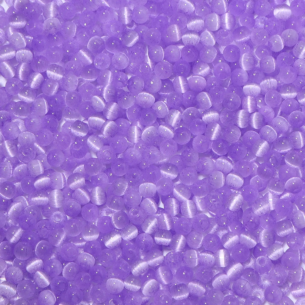 A close-up view of a colorful mix of 4mm cat eye glass beads used for jewelry making.