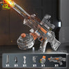 A clear plastic automatic electric UMP45 water blaster rifle is shown firing a stream of water in a dark setting.