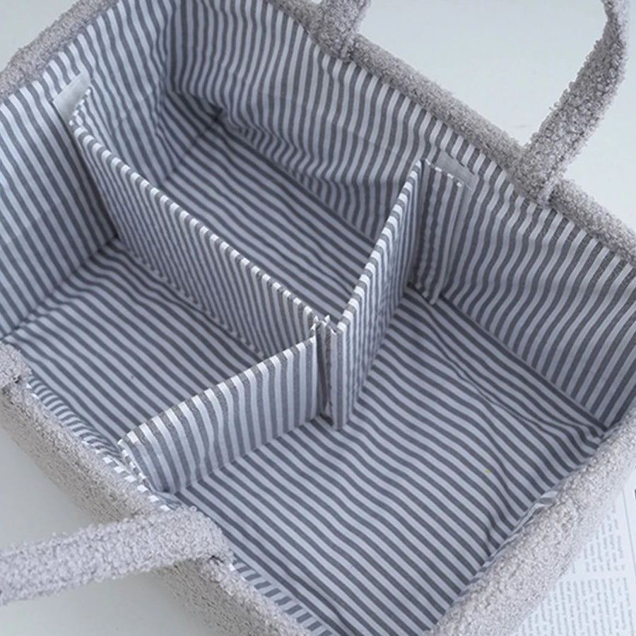 Sac multifonction bébé gris rayé avec intérieur et poignées texturé.