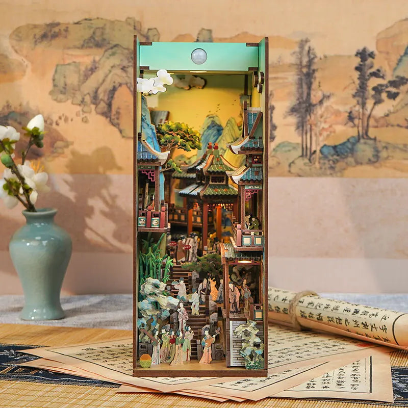 A wooden DIY book nook kit featuring miniature Japanese architecture and landscape with LED lighting.