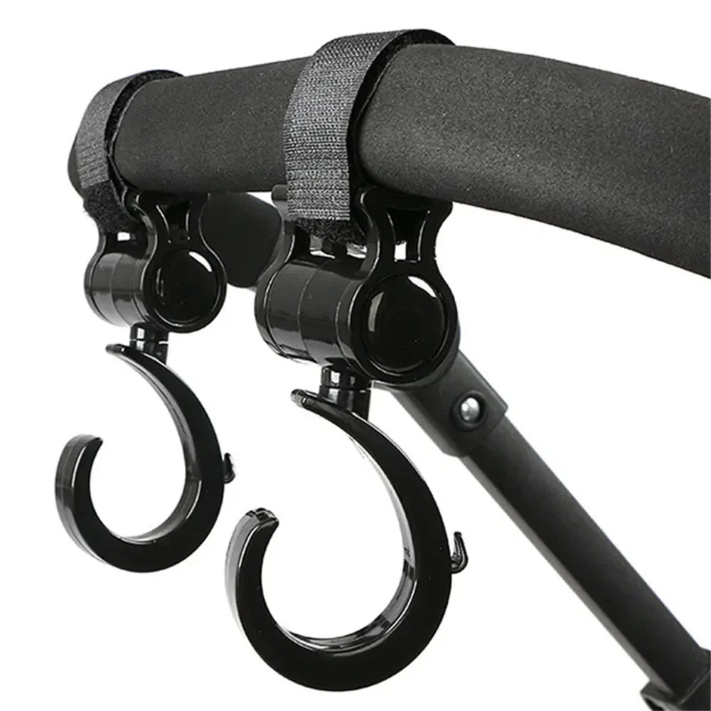 A close-up view of a black stroller hook with a rotating mechanism, designed for diaper bags and shopping.